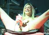 Dildo test door blonde hoer op het podium.
