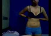 Verlegen meisje geeft een striptease voor de webcam
